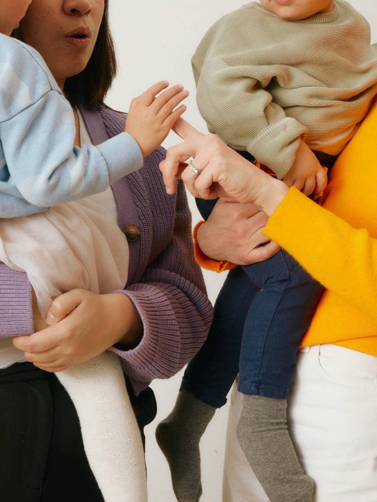 Close up of two caregivers holding babies